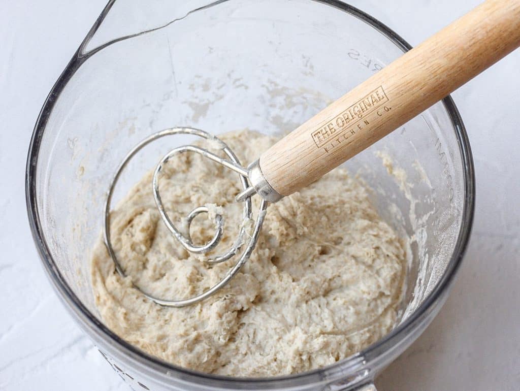 dough being mixed with a dough whisk