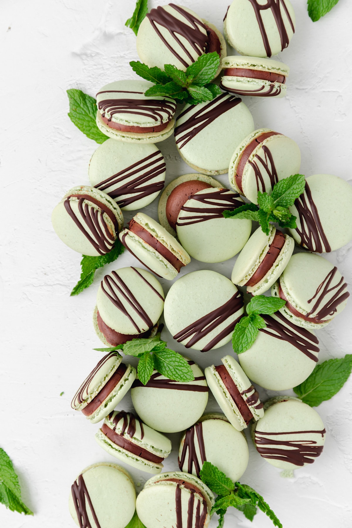 mint chocolate macarons with chocolate drizzled on top