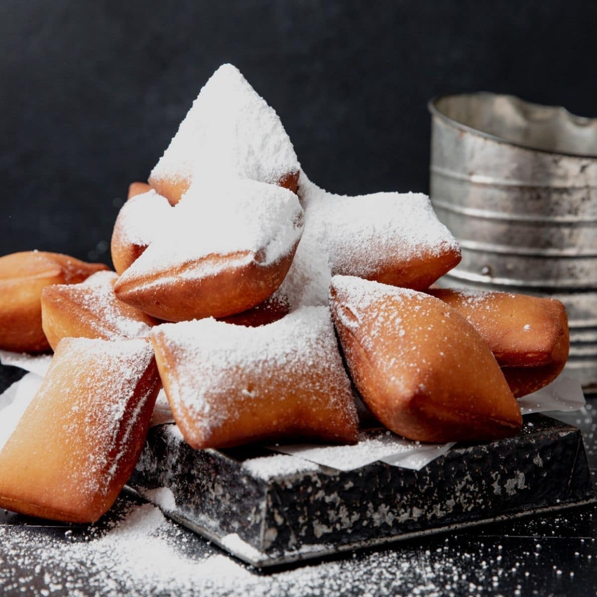 close up shot of sourdough beignets with powdered sugar