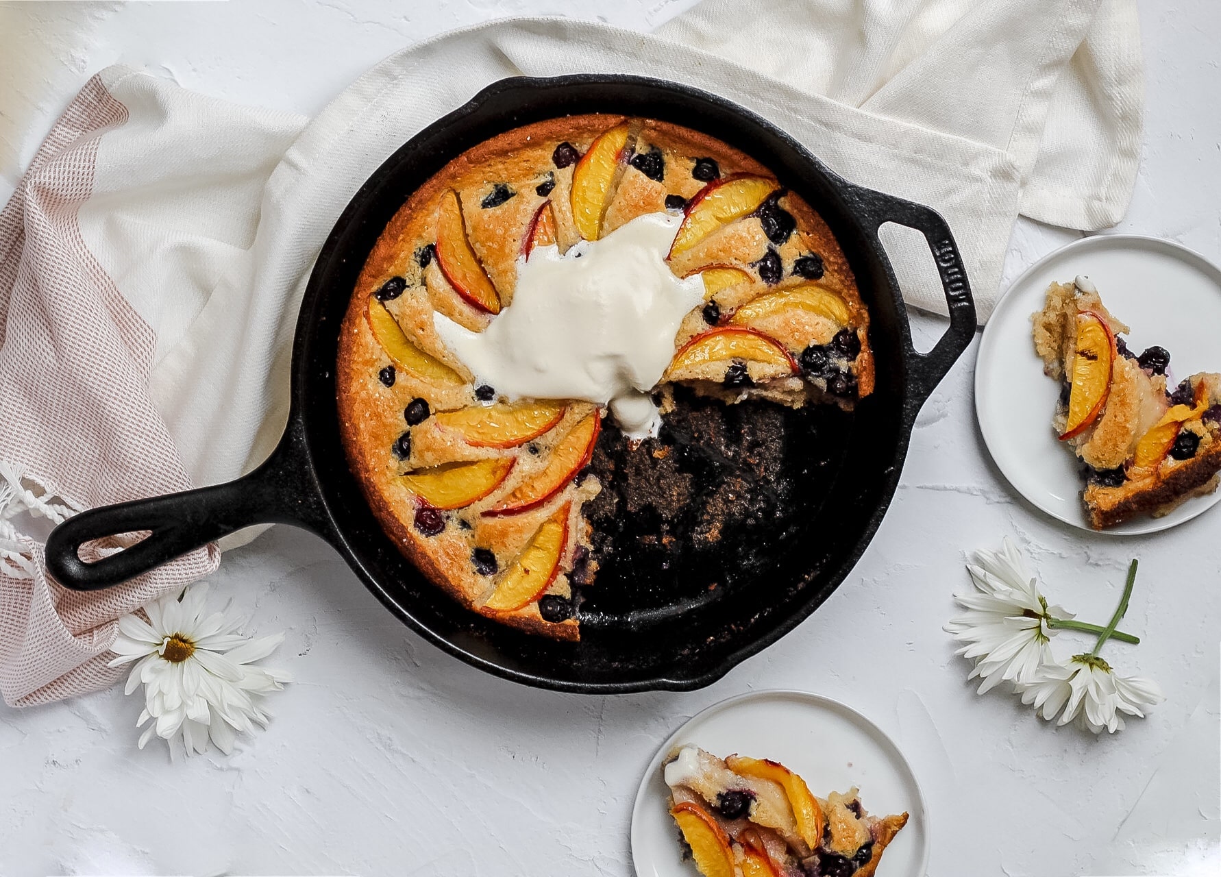 peach blueberry cobbler with whipped cream and pieces cut out