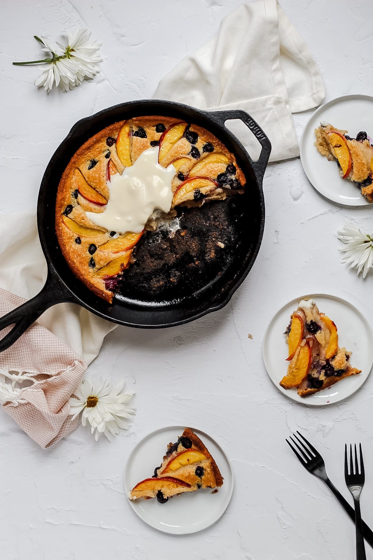 peach blueberry cobbler with whipped cream and pieces cut out