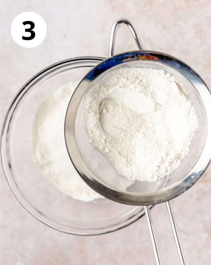 sifting together almond flour and powdered sugar into large bowl