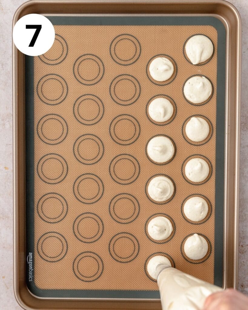 piping macarons onto baking sheet