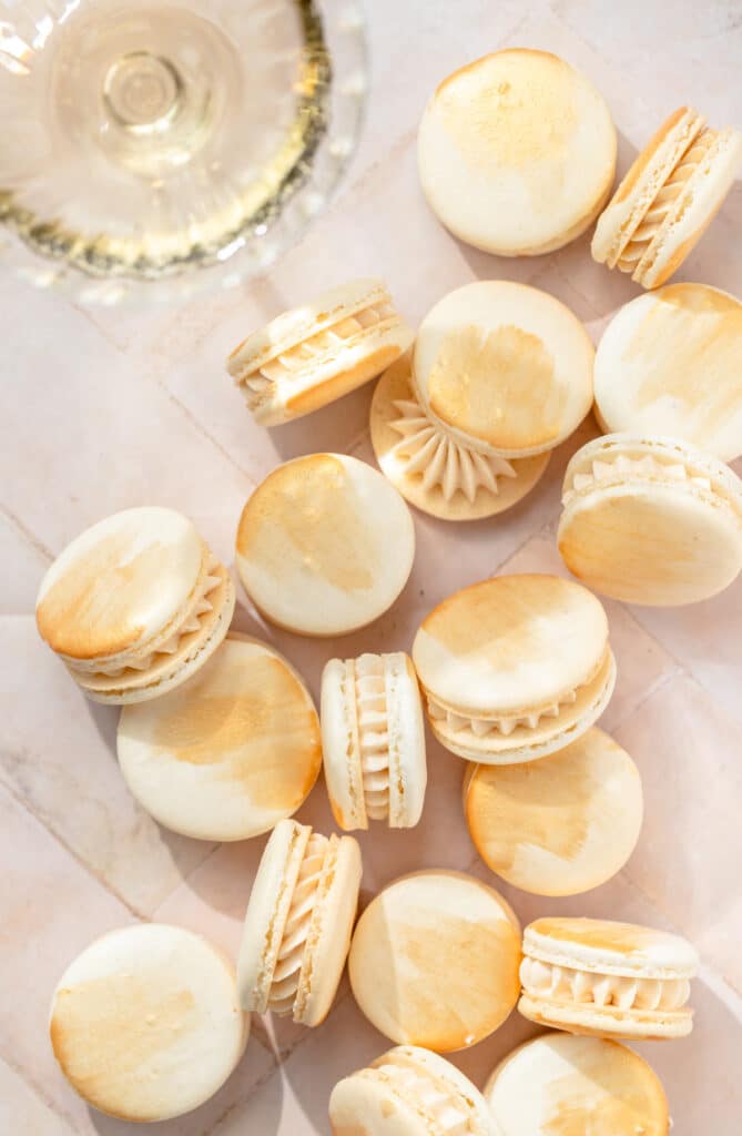 champagne macarons with gold paint and glass of champagne 