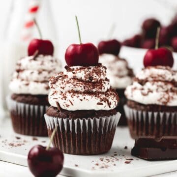 close up shot of black forest cupcakes with cherry on top