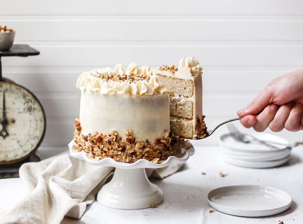 brown butter hazelnut layer cake with slice being pulled out