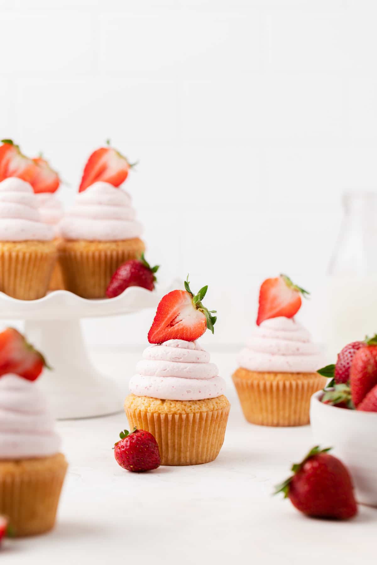 vanilla cupcakes with strawberries on top