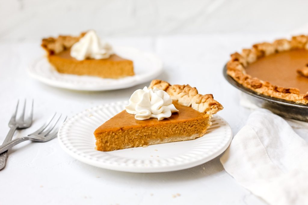 slice of bourbon pumpkin pie with whipped cream on top