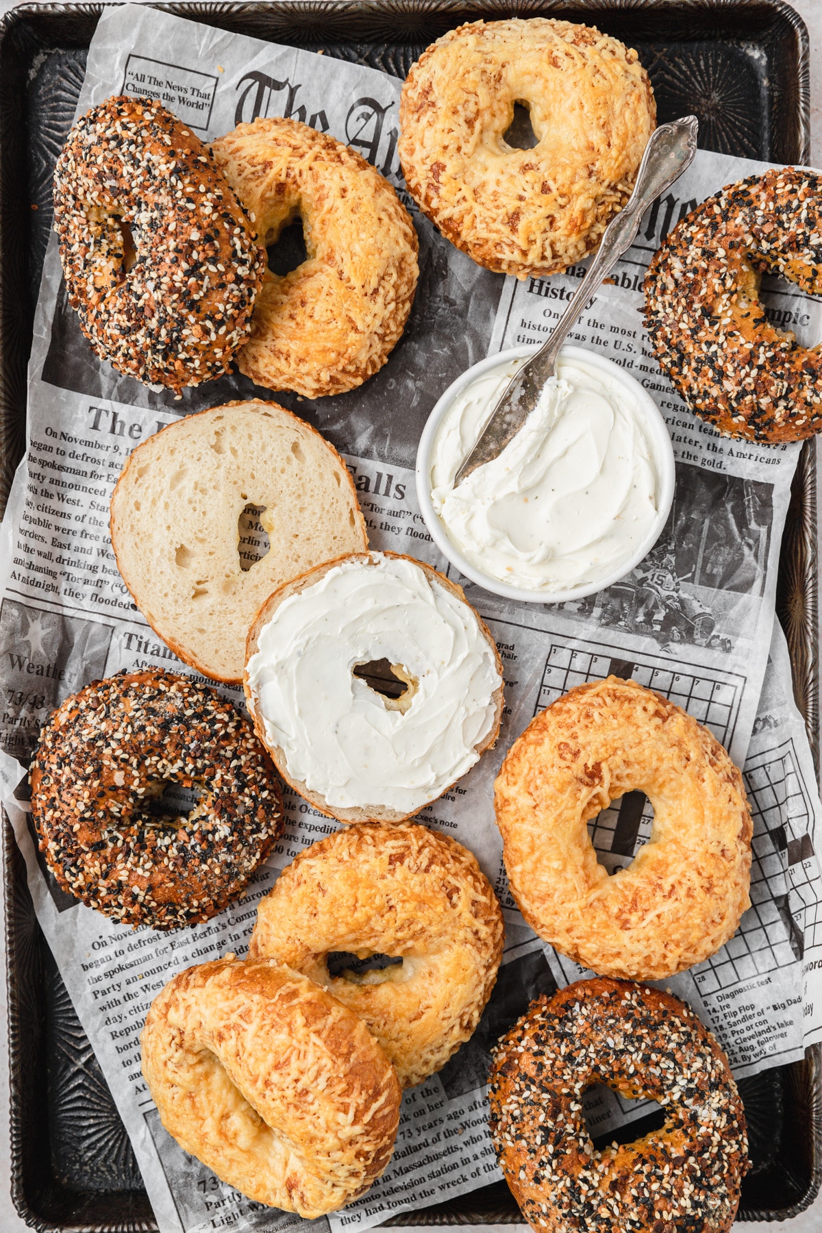 sourdough bagels with cream cheese on newspaper 