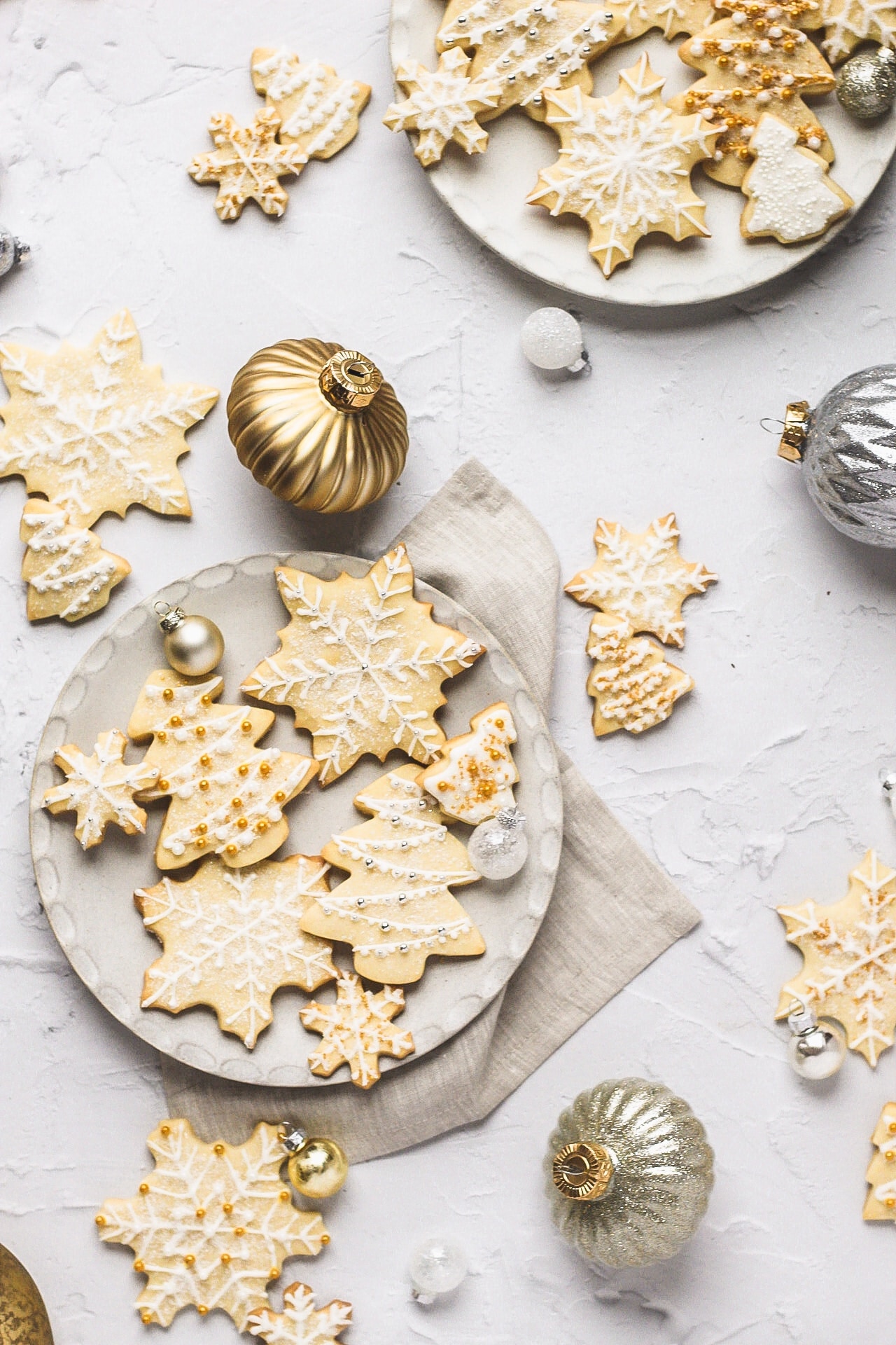 snowflake and christmas tree shortbread cutout cookies with royal icing and sprinkles