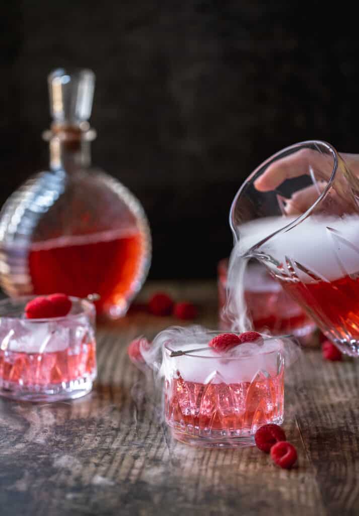 pouring dry ice into cocktails with raspberries