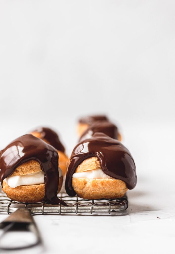 chocolate cream puffs on cooling rack