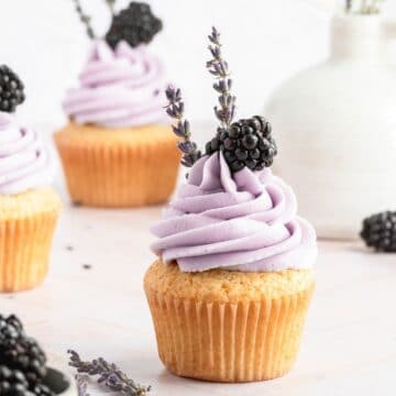 close up shot of blackberry lavender cupcakes with blackberry on top.