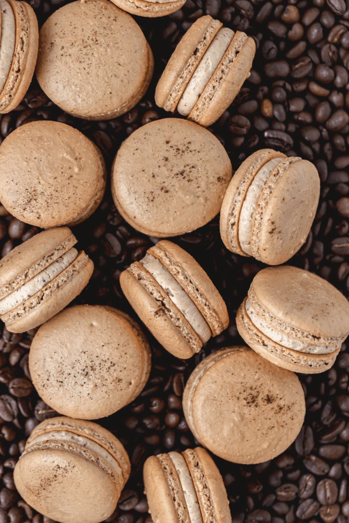 espresso macarons with espresso buttercream on bed of coffee beans