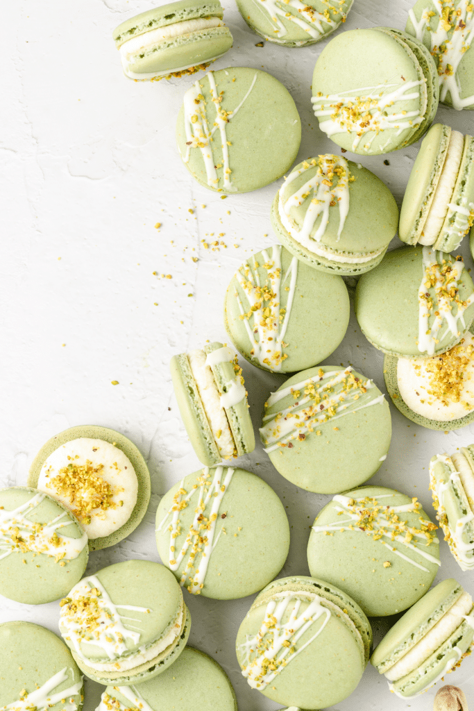 spread of pistachio macarons with white chocolate drizzled on top
