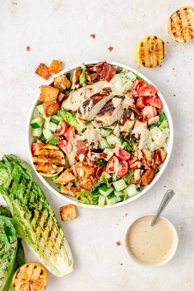 grilled chicken caesar salad in bowl with grilled romaine