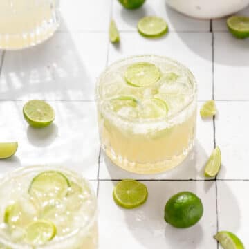 close up shot of key lime margaritas with slices of key limes