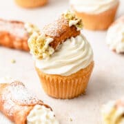 close up shot of cannoli cupcakes with mini cannoli on top