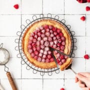 close up shot of raspberry almond frangipane tart with fresh raspberries on top