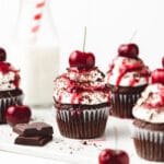 close up shot of black forest cupcakes with fresh cherries