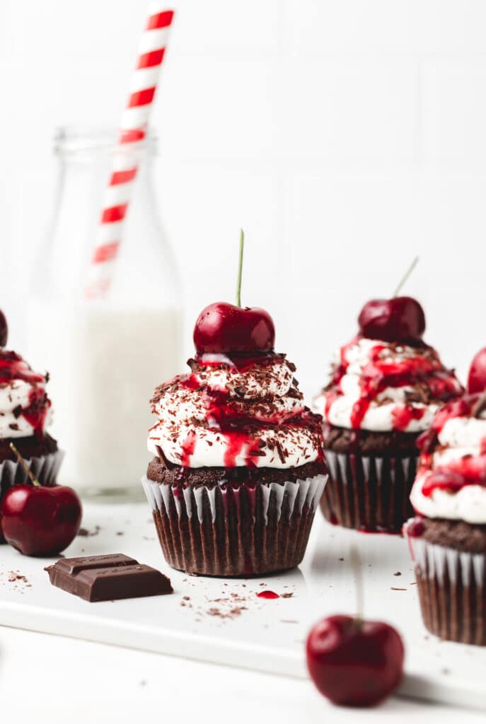 Black Forest cupcakes topped with whipped cream and cherries.