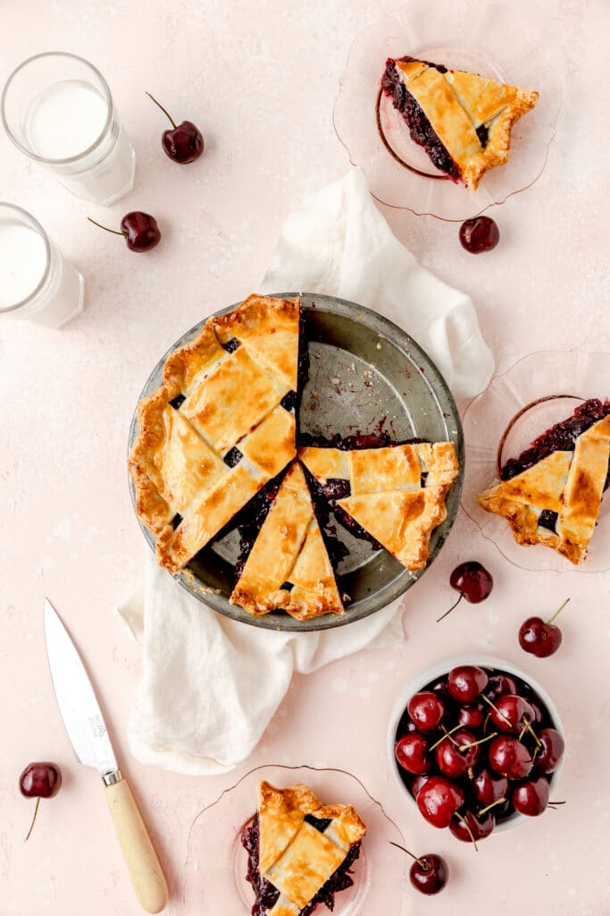 cherry pie with lattice pie crust and slices on plates