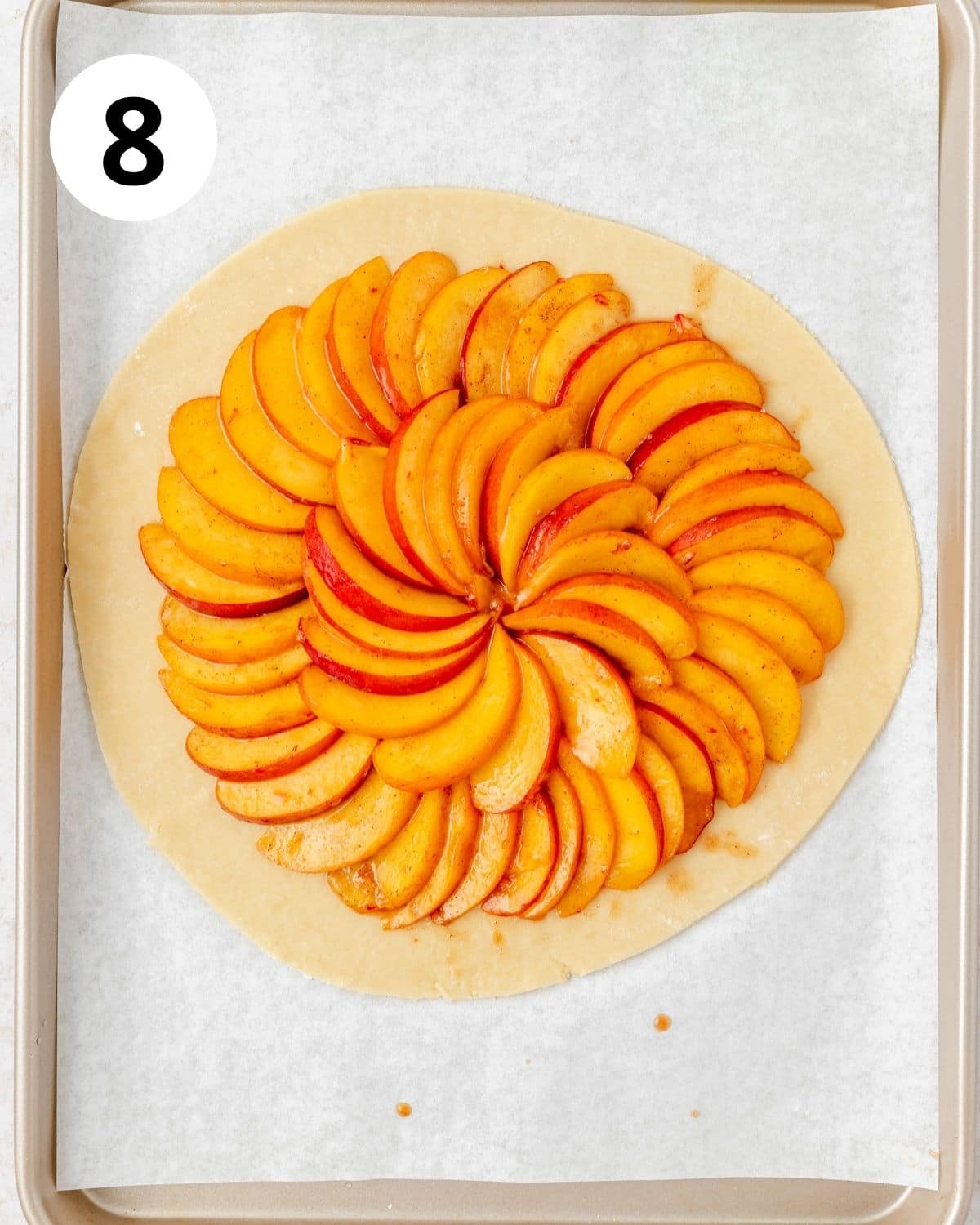 spiced peaches arranged on pie dough