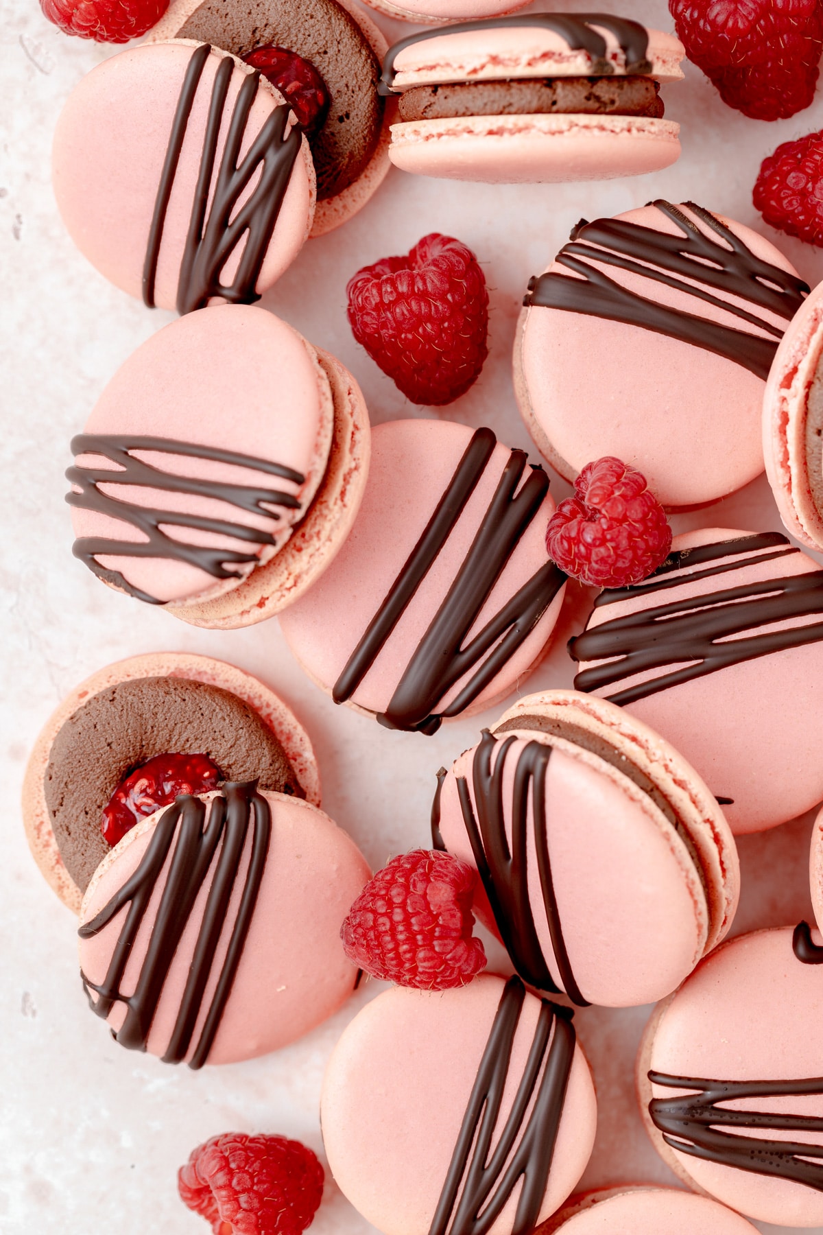 pink macarons with chocolate drizzle and raspberries