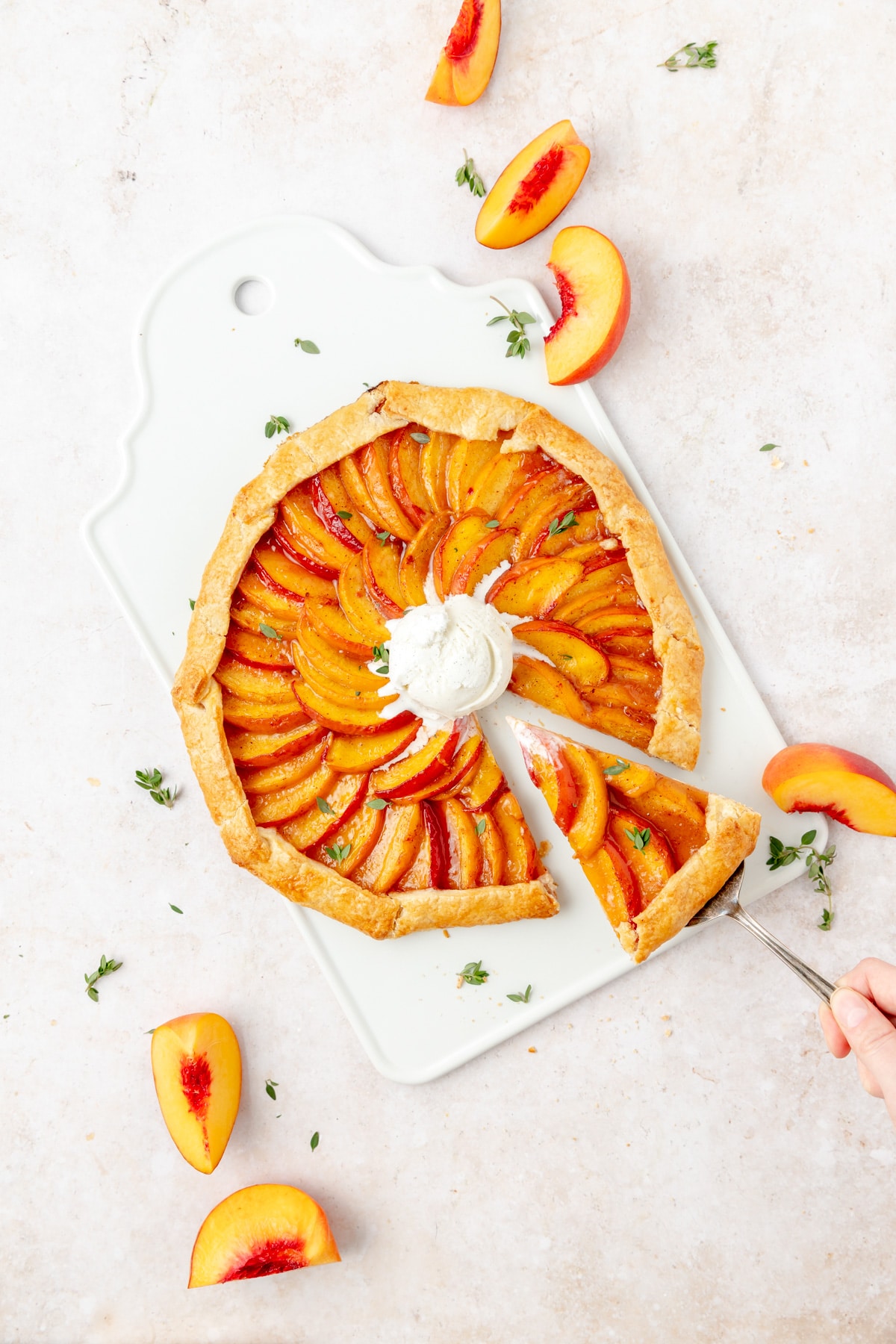 rustic peach galette with slice being pulled out
