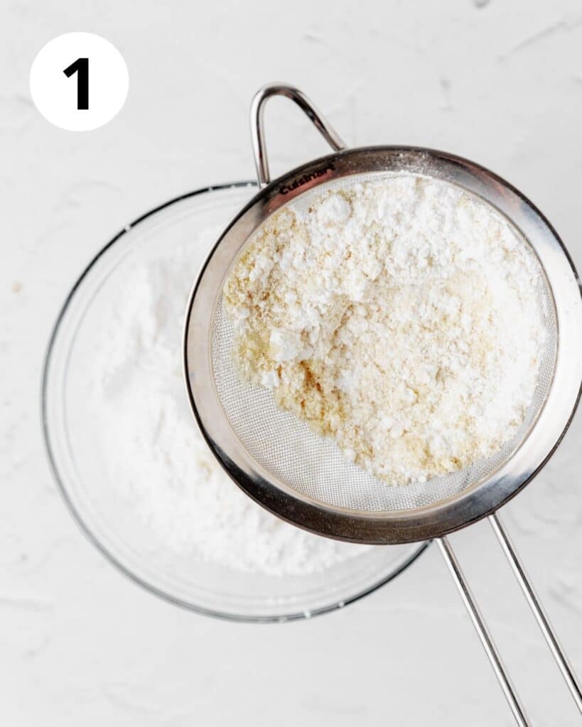 sifting almond flour and powdered sugar together in bowl