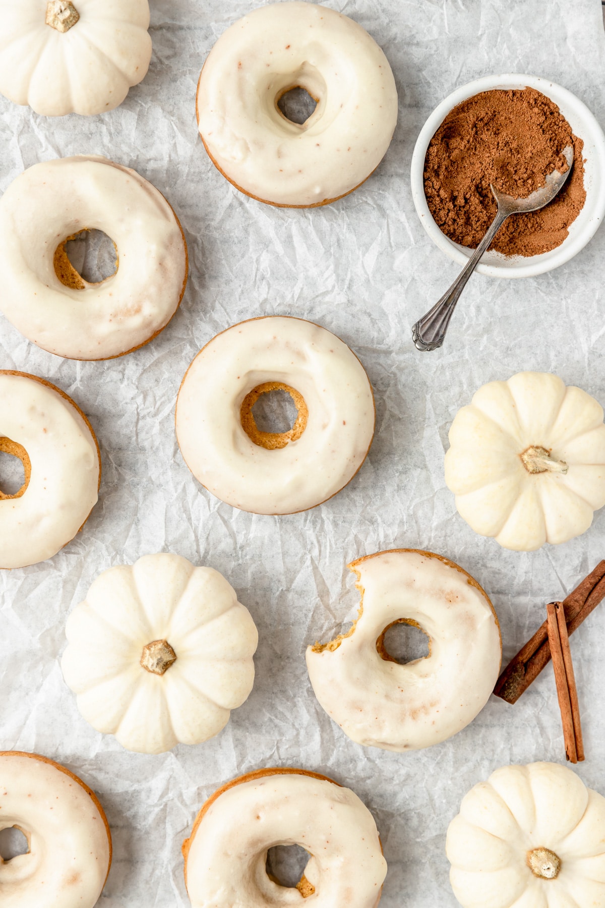 brown butter baked donuts on a cooling rack with mini pumpkins