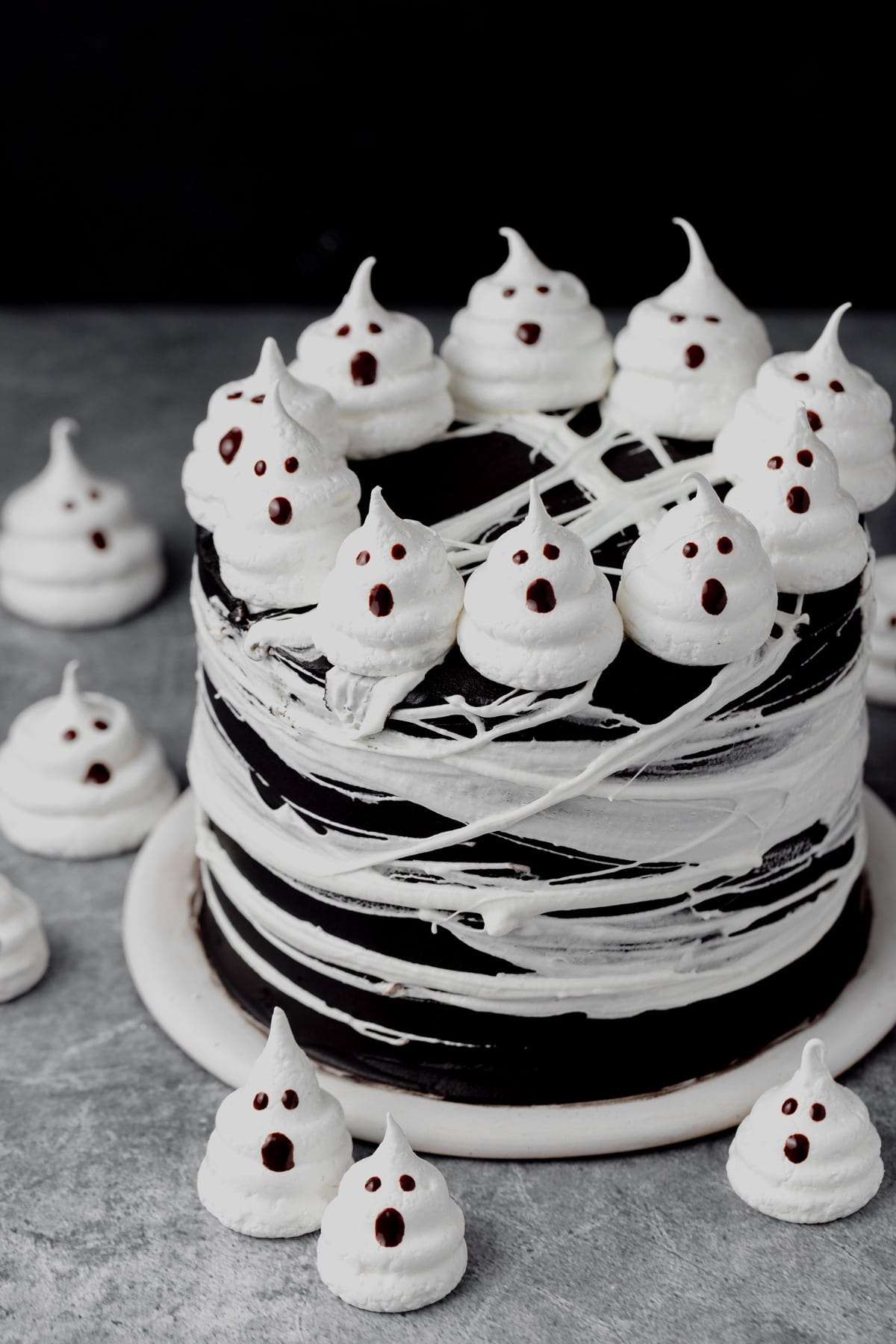black cocoa cake with ghost meringues on top