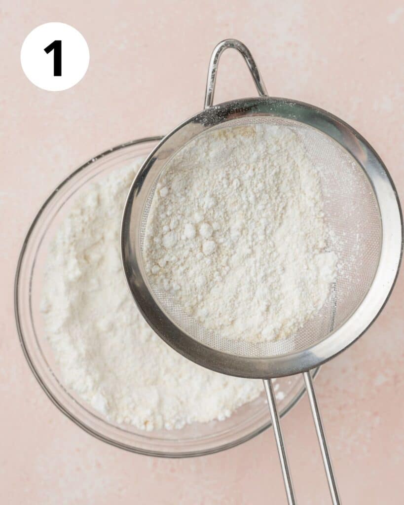 sifting together powdered sugar and almond flour into bowl