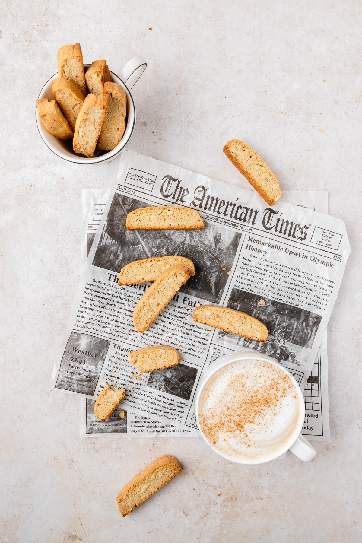 brown butter almond biscotti arranged on newspaper with coffee