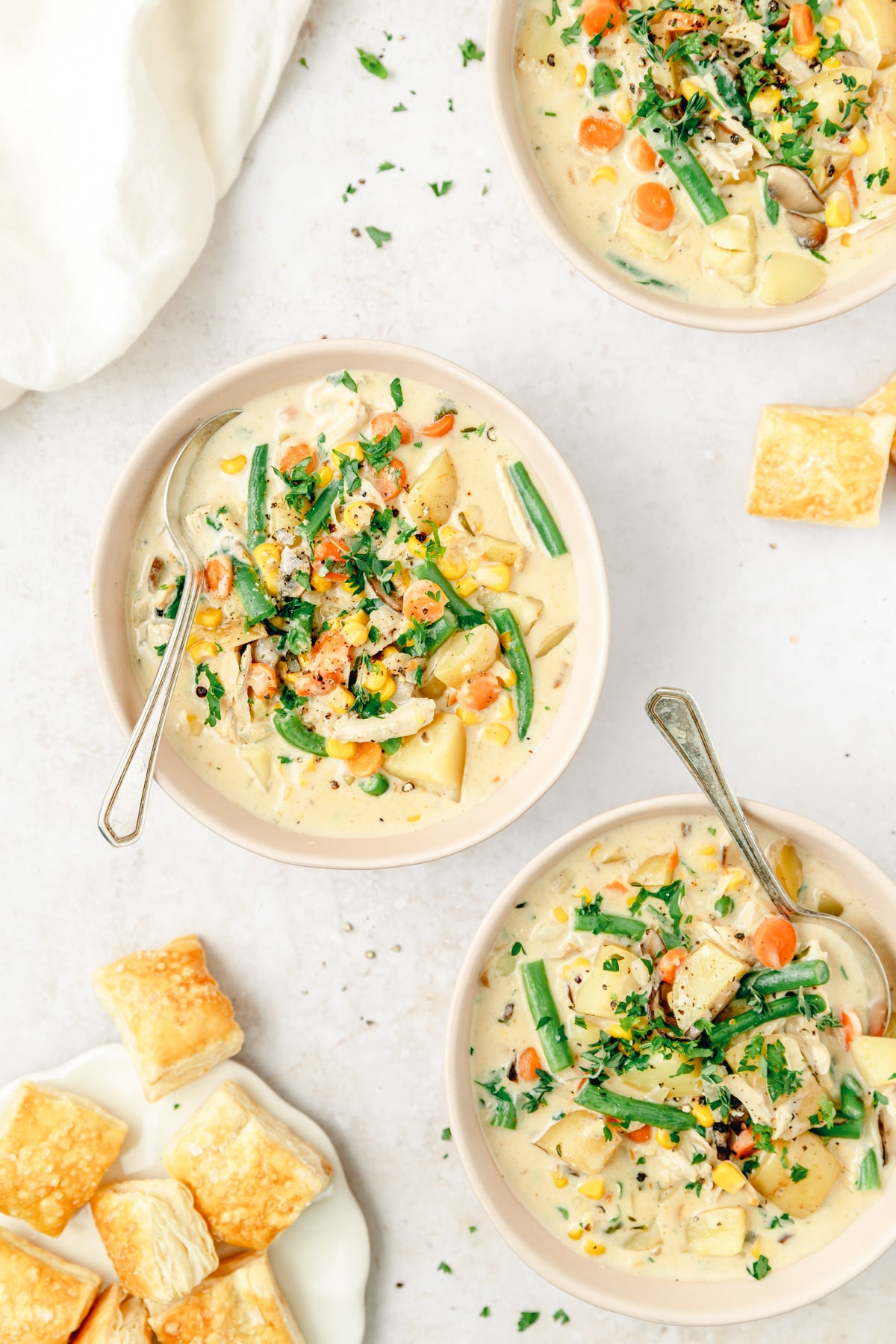 three bowls filled with creamy chicken pot pie soup