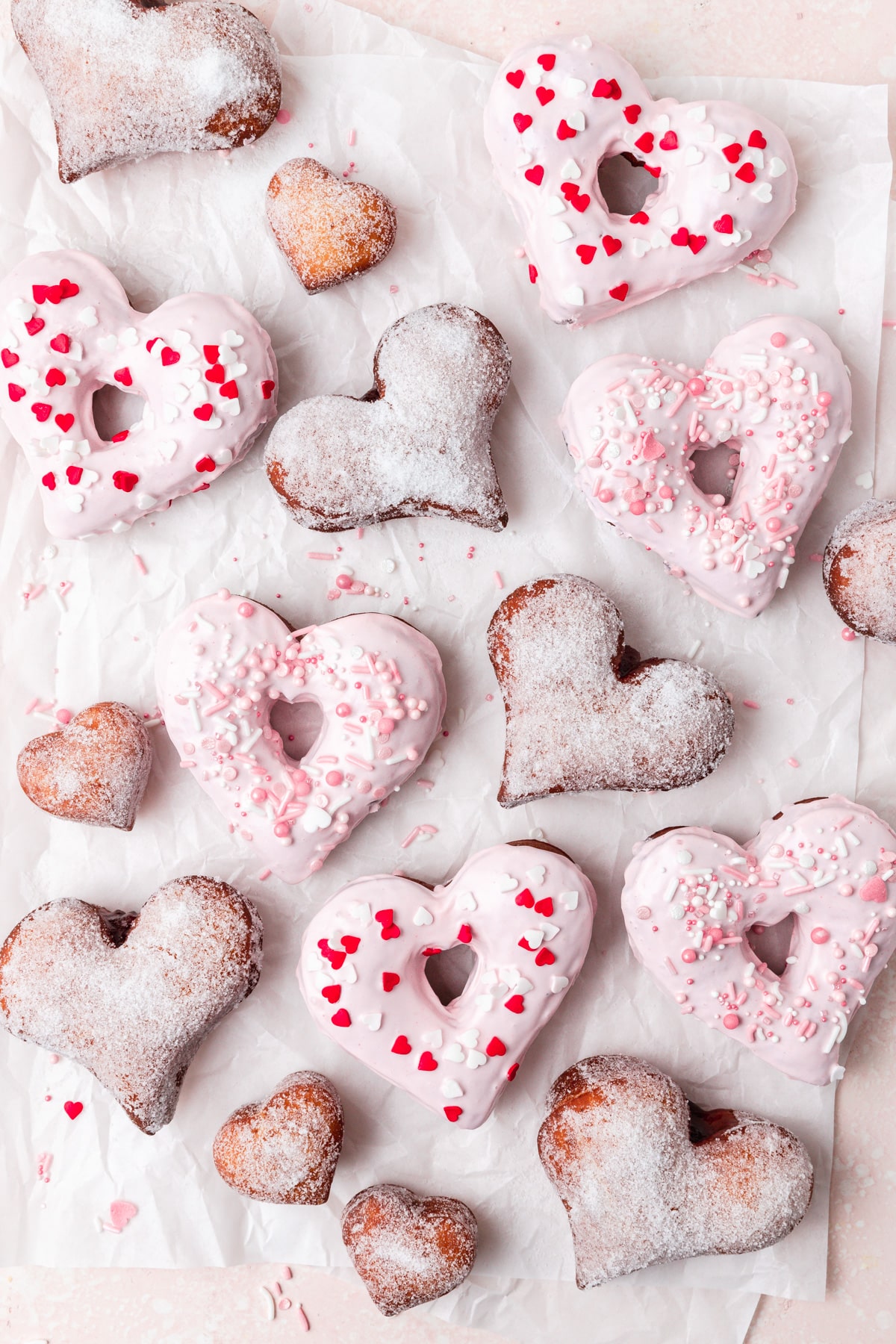 heart shaped donuts, some with pink glaze and some filled with jelly.