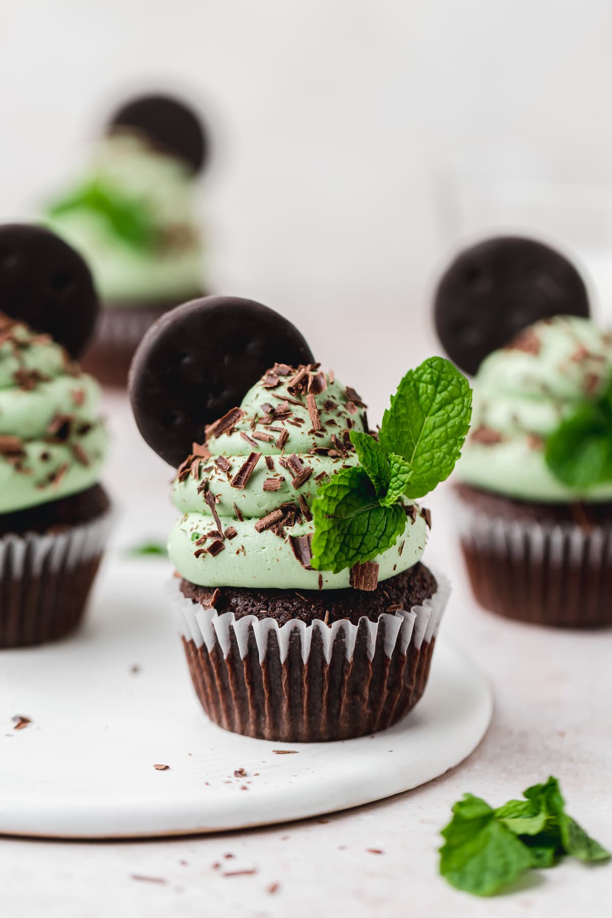 mint chocolate cupcakes garnished with thin mint cookie and chocolate curls.