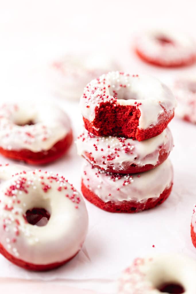 stack of red velvet baked donuts with cream cheese frosting.