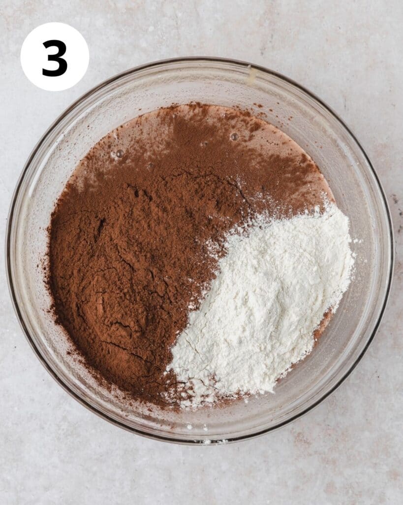 adding cocoa powder and flour to brownie batter.