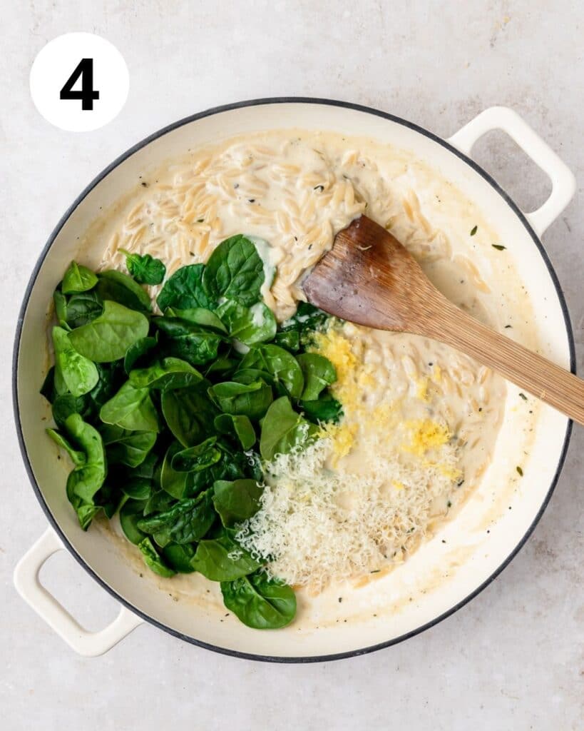 adding spinach lemon and cheese to pot of orzo.