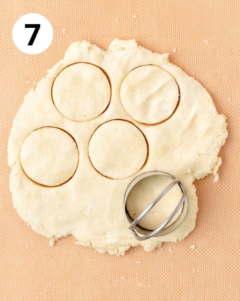 cutting out small round cream biscuits.