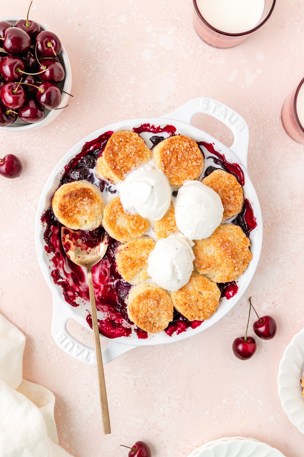 cherry cobbler with biscuit topping and ice cream on top.