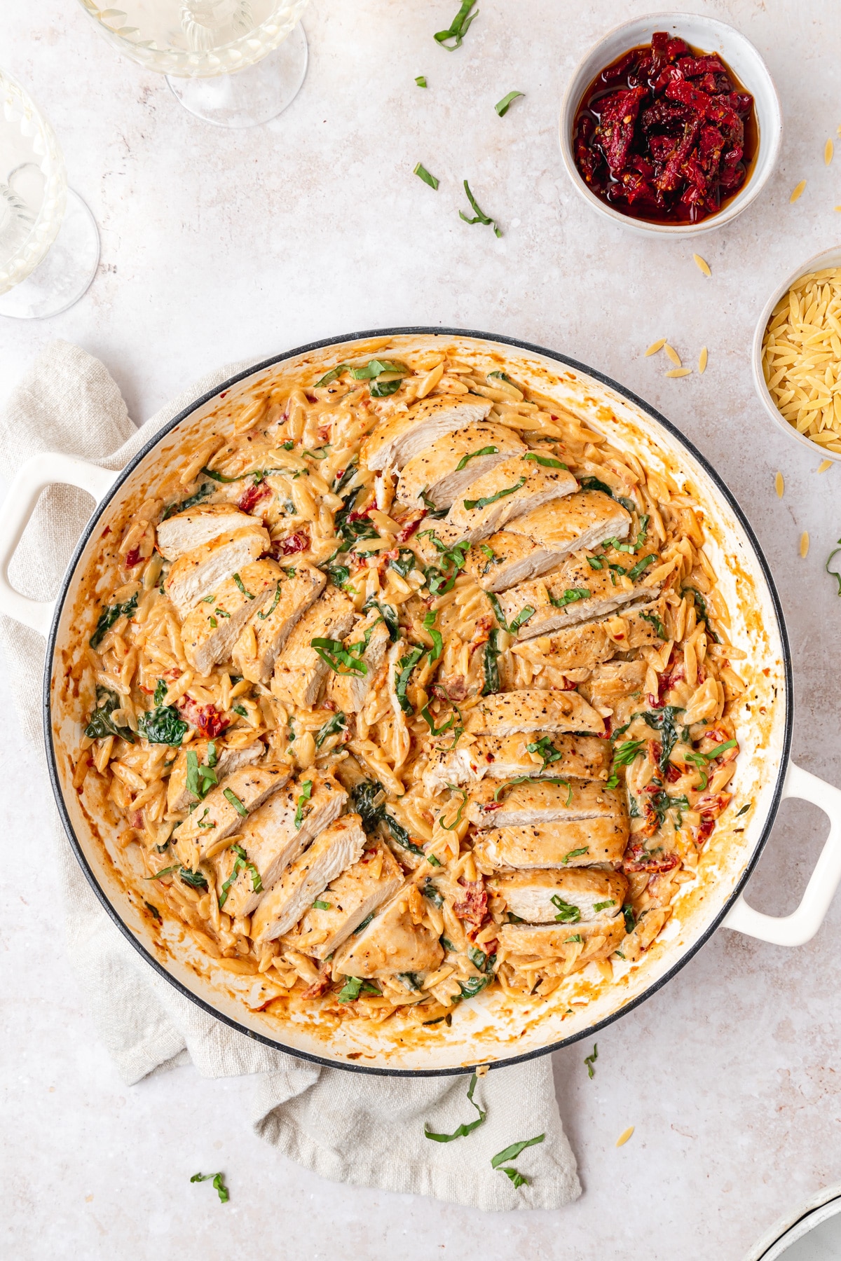sliced chicken breasts on top of tuscan orzo.