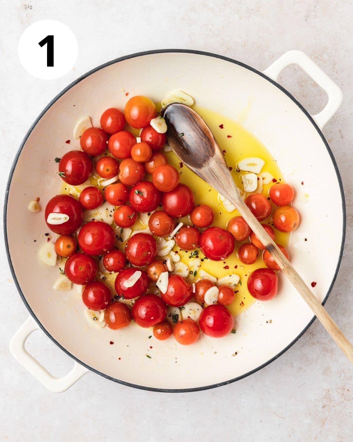 cherry tomatoes, garlic, and olive oil in pan.