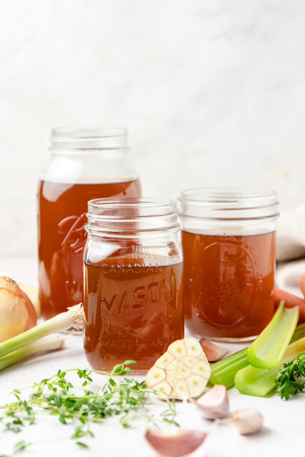 three glass jars filled with homemade vegetable stock/broth.
