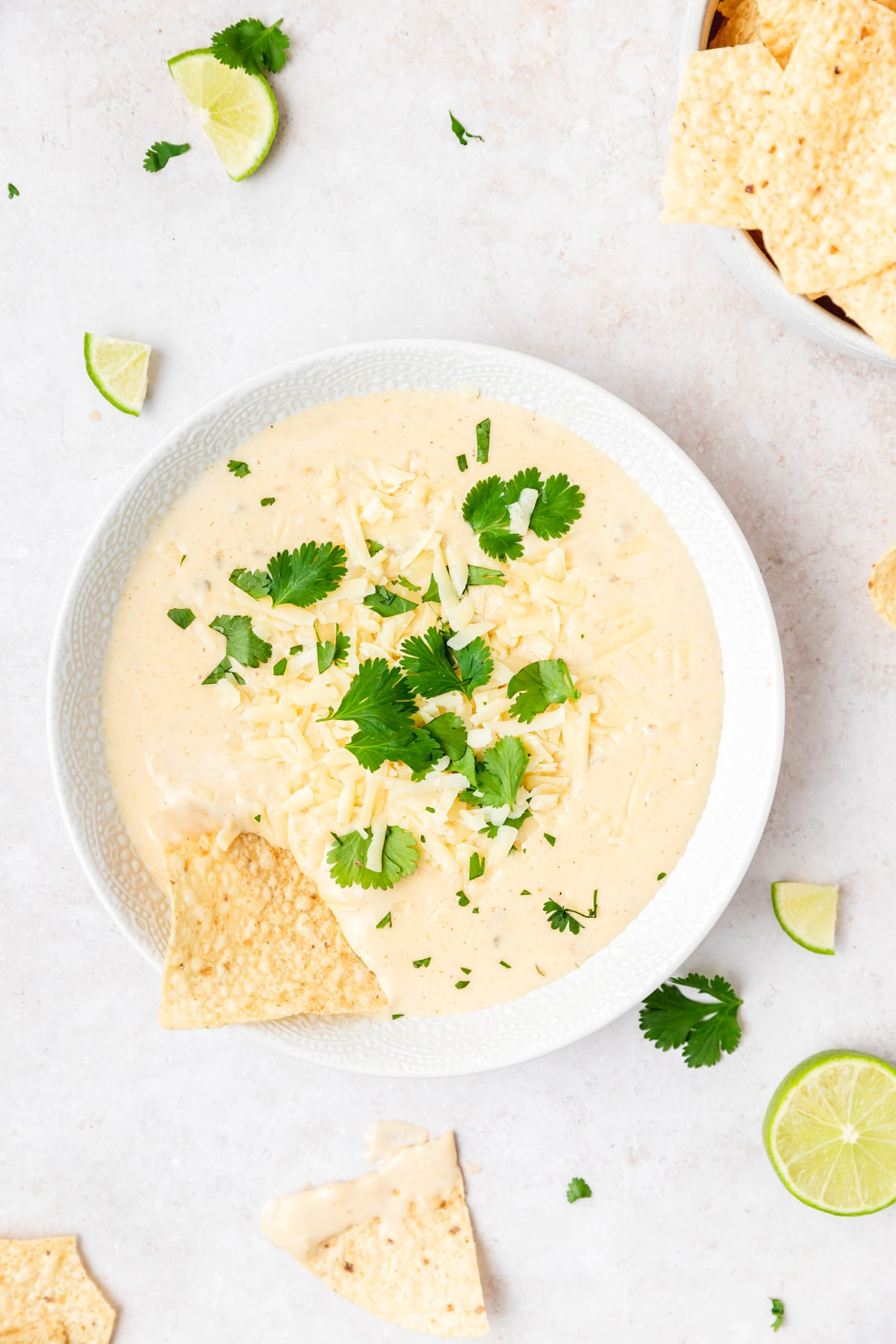 bowl of creamy white queso dip with tortilla chips.