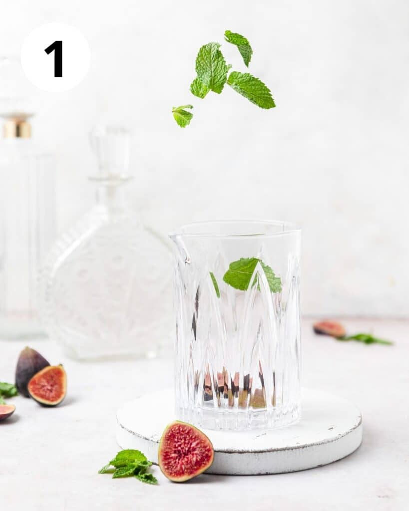 adding figs and mint to cocktail glass.