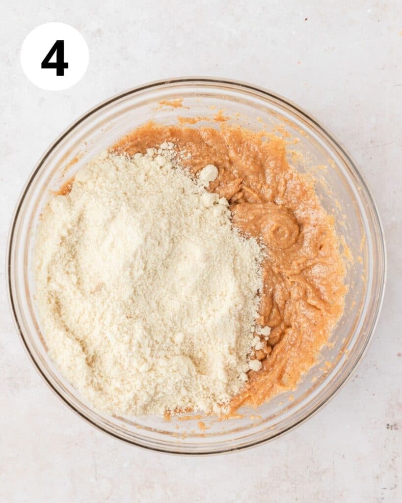 adding almond flour to cookie dough.