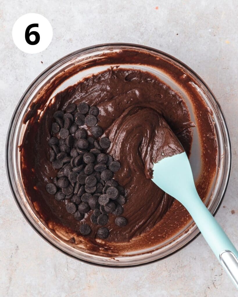 mixing chocolate chips into chocolate bread batter.
