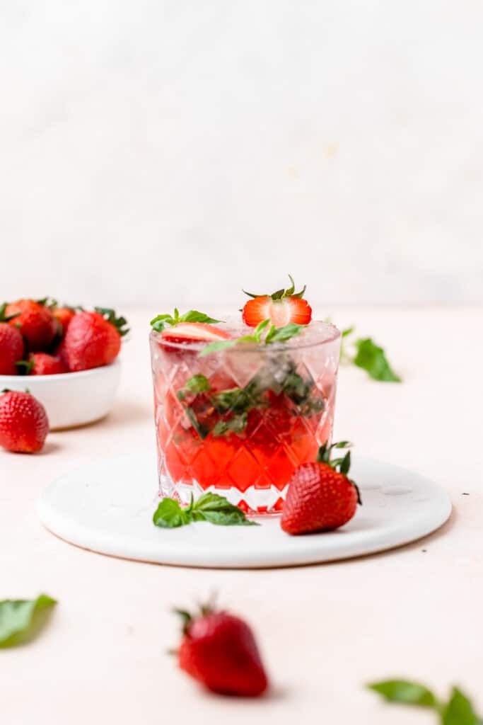 topping mojito with fresh basil and sliced strawberries.